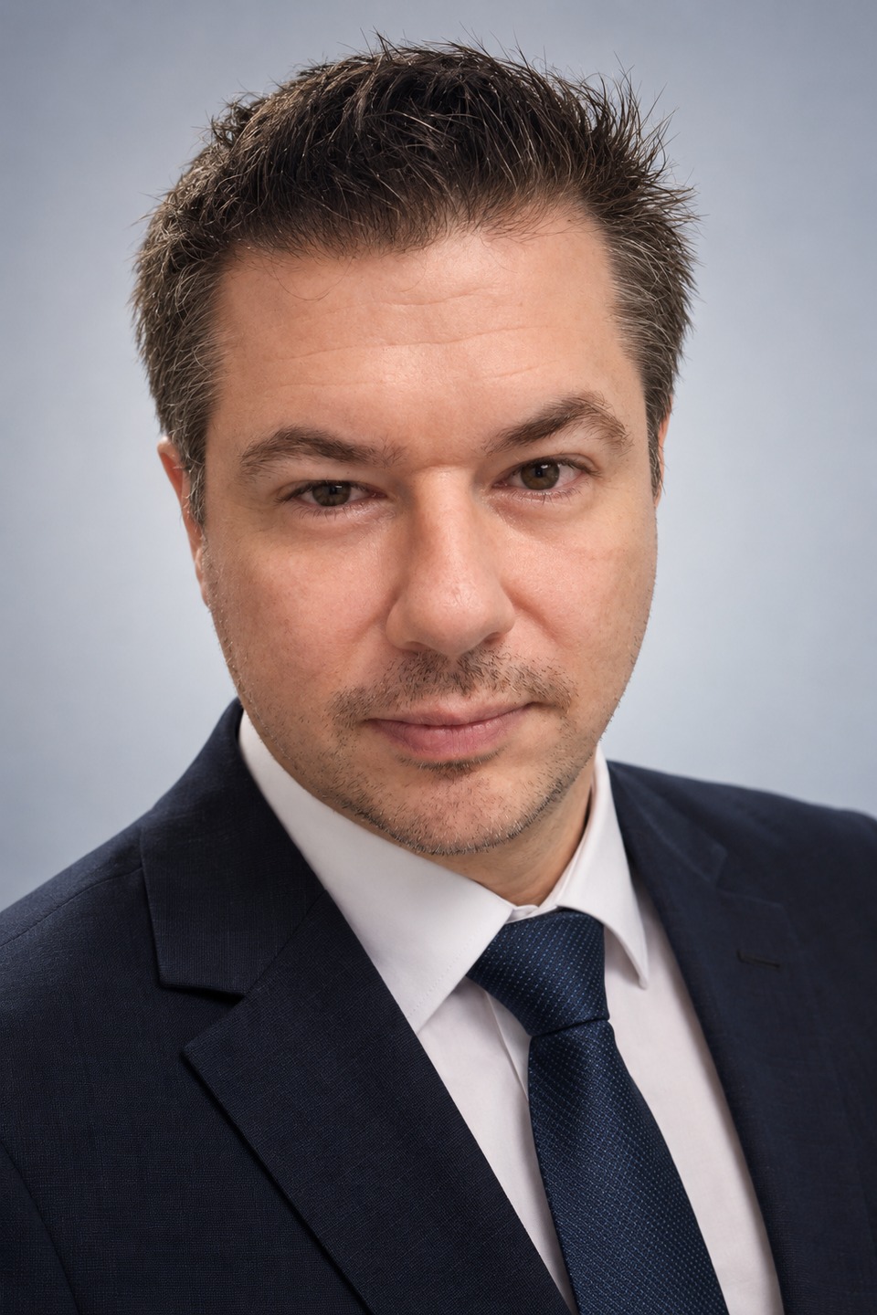 Retrato de Daniel Biasoli, com terno azul-marinho e camisa branca.
